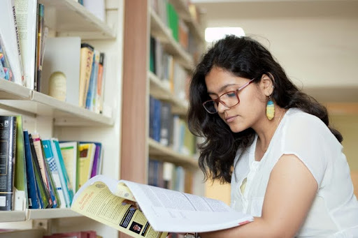 Woman reading a book in a library.