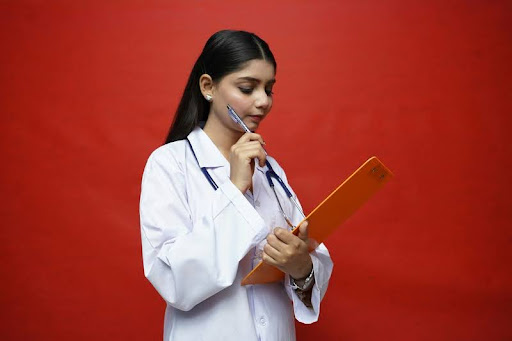 Nurse holding a record and a pen, ready to take notes.
