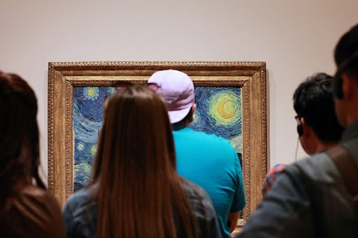 People viewing a painting in an art gallery