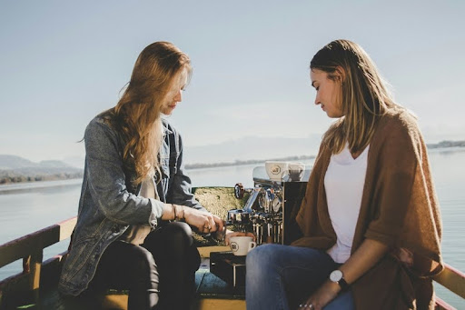 Two women sitting on a boat, engaged in a casual conversation.