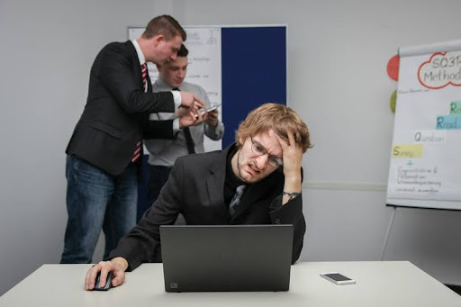 Frustrated man sitting at a desk with a laptop