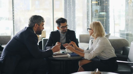 Three colleagues in a serious team discussion at a table