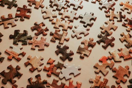 A large group of puzzle pieces scattered on a table.