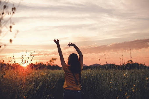 Woman stretching her hands during golden hour