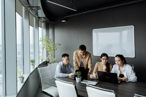 Team of colleagues gathered around laptops in discussion
