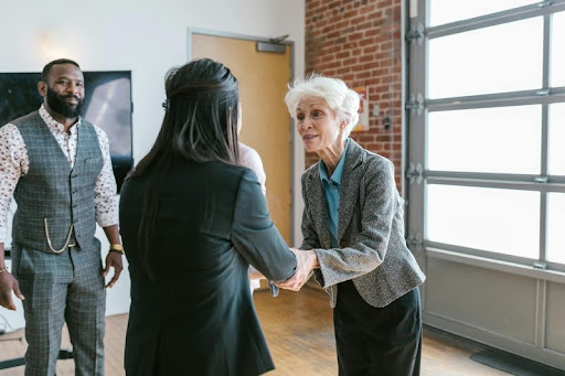 Young female entrepreneur shaking hands with an investor in a modern office.