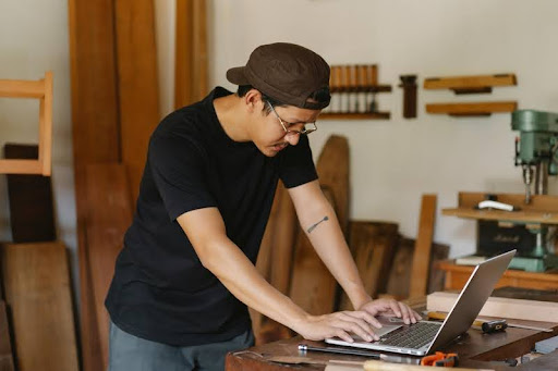 Man standing and looking curiously at his laptop