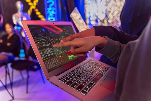 Two people looking at a laptop screen displaying text