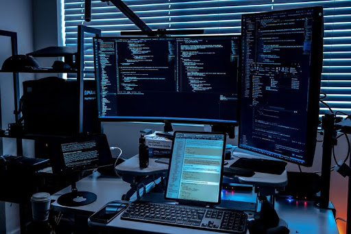 Desk setup with multiple monitors displaying cybersecurity data