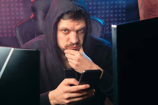 Man in black hoodie looking at smartphone