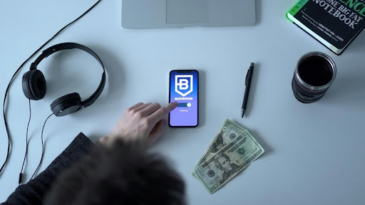 Person using a smartphone with cash on a table