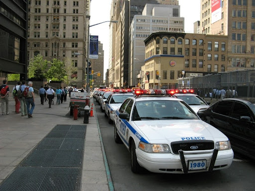 Police vehicles driving down a city street.