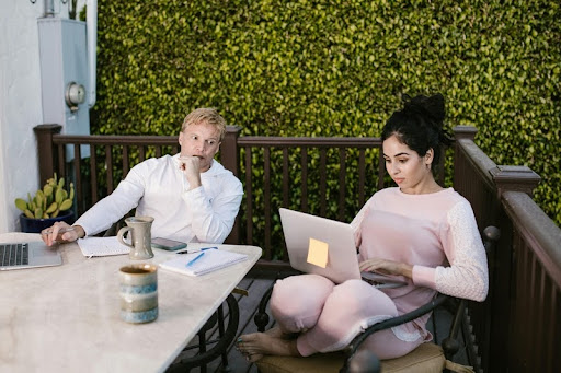 Two people working on laptops at a shared table