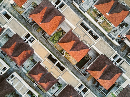 Aerial view of suburban houses with brown roofs arranged in a grid pattern