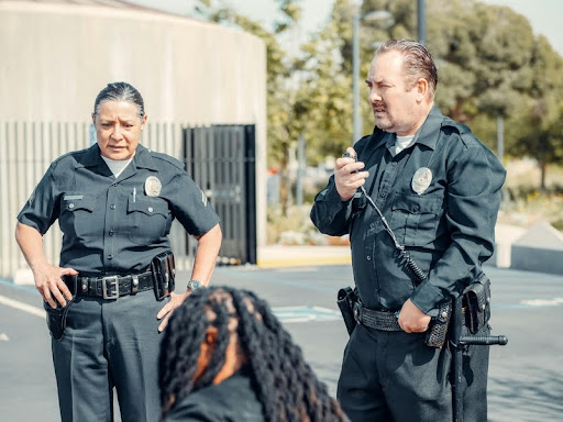 Two uniformed police officers communicating via radio.