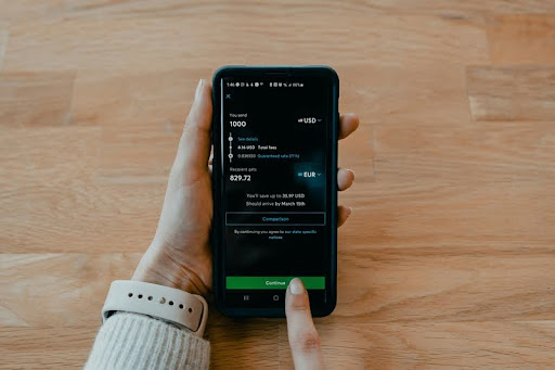 Person holding a smartphone displaying scholarship-related text messages.