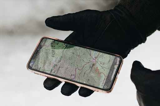 Person holding smartphone with location app open