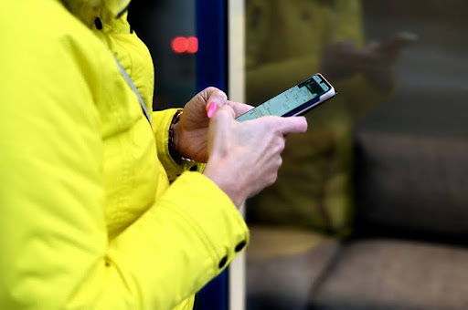 Person holding a smartphone and looking at the screen with focus