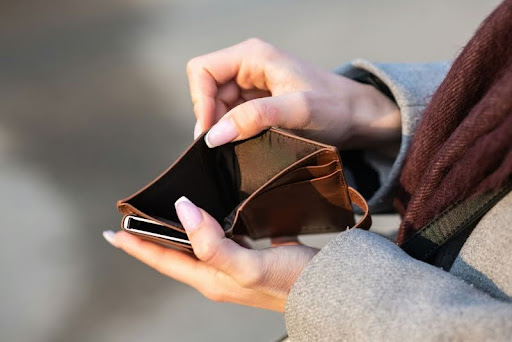 Frustrated woman looking at her empty wallet