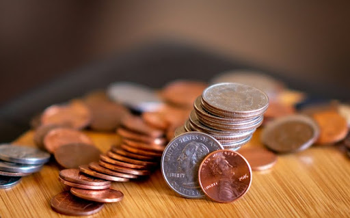 Silver and gold coins scattered on a wooden table