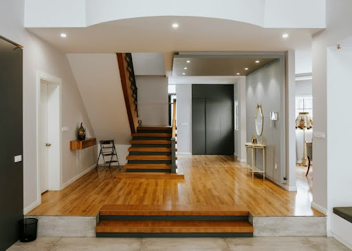 Brown wooden staircase next to a white wooden door