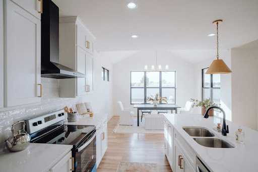 Modern kitchen with white cabinets, quartz countertops, and stainless steel appliances.
