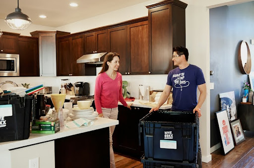 Man and woman standing together in a bright, modern kitchen.