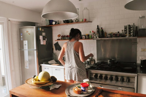 Woman standing in a modern kitchen next to a stovetop oven