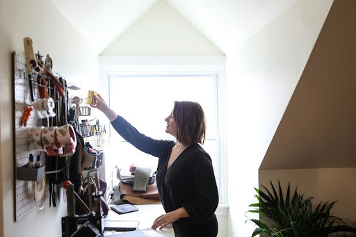 Woman in black organizing home decor during a DIY project.