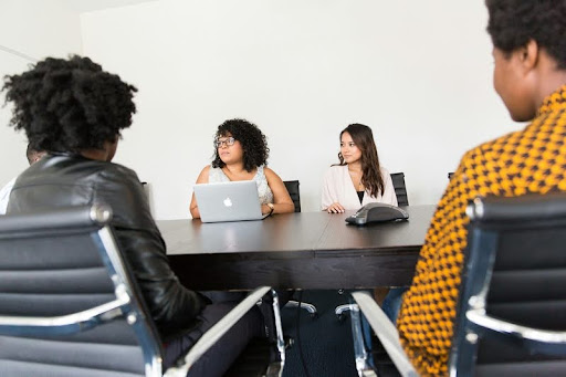 Woman speaking while seated at a table in a workplace setting