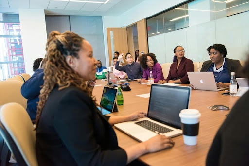 Women in an office meeting with laptops open