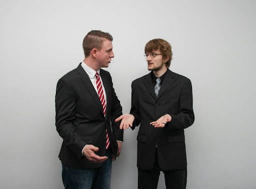 Two men in suits having a tense conversation