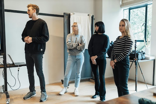 Man and three women engaged in a workplace presentation.