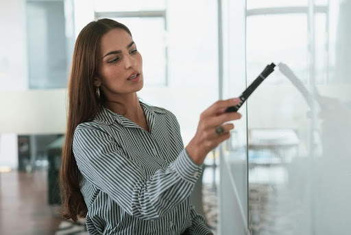 Businesswoman giving a presentation to colleagues in a modern office.