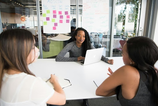 Three professional women having a serious discussion in a modern office.