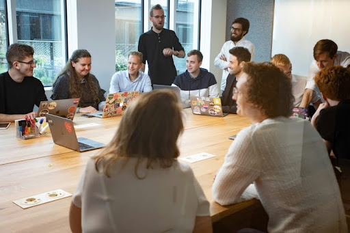 Diverse team discussing around a round table with laptops