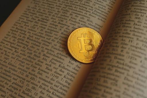 Bitcoin coin resting on an open book
