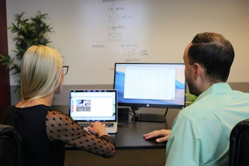 Co-workers collaborating around a desk in a modern office setting.