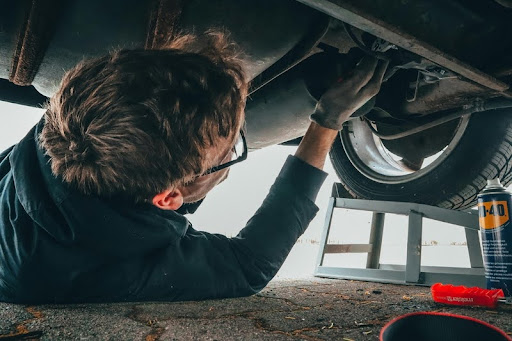 Man repairing a car engine under the hood