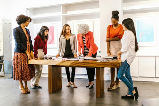 Women having a workplace discussion around a conference table.