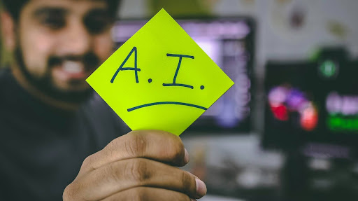 Man holding a sticky note with "AI" written on it
