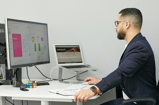 Man working on a laptop at a desk, focused on his computer screen.
