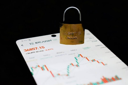 Padlock resting on a smartphone showing a cryptocurrency exchange interface