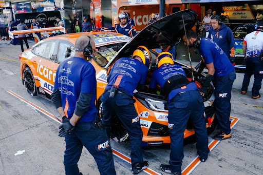 Racing pit crew servicing a car during a pit stop