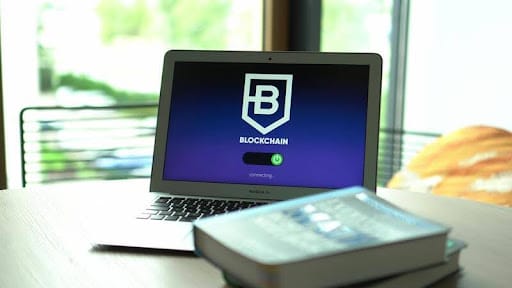 Laptop on a table displaying a blockchain interface