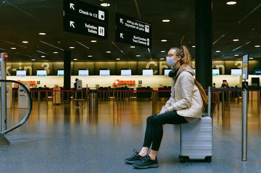 Woman sitting on a suitcase in an airport terminal