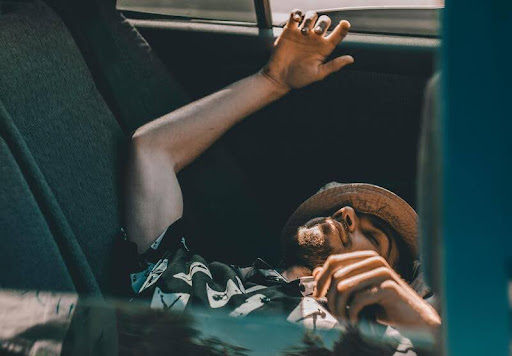 Man sleeping in his parked car with seat reclined