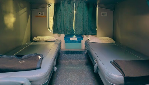 Two beds arranged inside an Amtrak sleeper train cabin