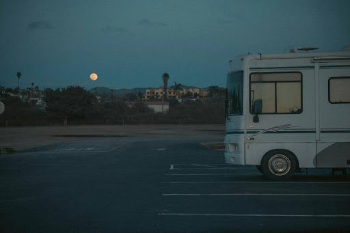 RV parked in a quiet parking lot at night