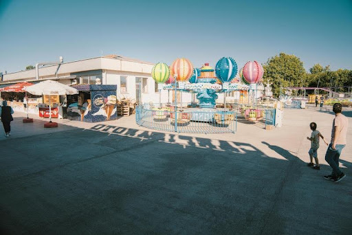 Parent holding child’s hand at entrance to a theme park
